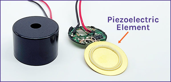 A piezo buzzer opened up to show its round piezoelectric disc