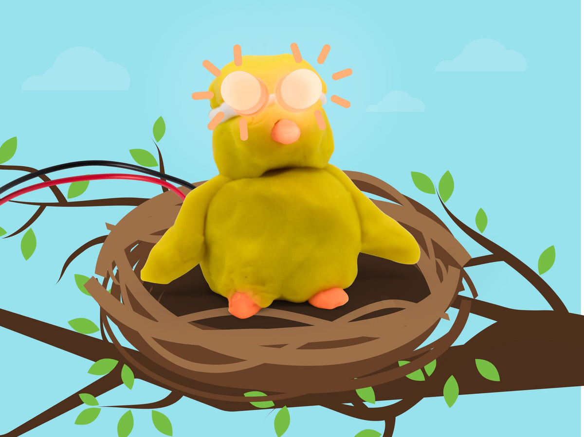 Yellow dough chick with glowing LED eyes and an orange beak sitting in a nest