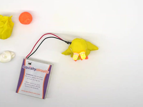 Yellow dough chick with glowing LED eyes, wired to the battery holder