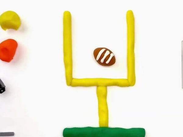 Brown dough football with white laces in front of the goalpost