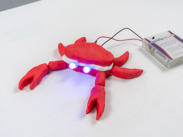 Crab with two glowing LED eyes, wired to the battery holder
