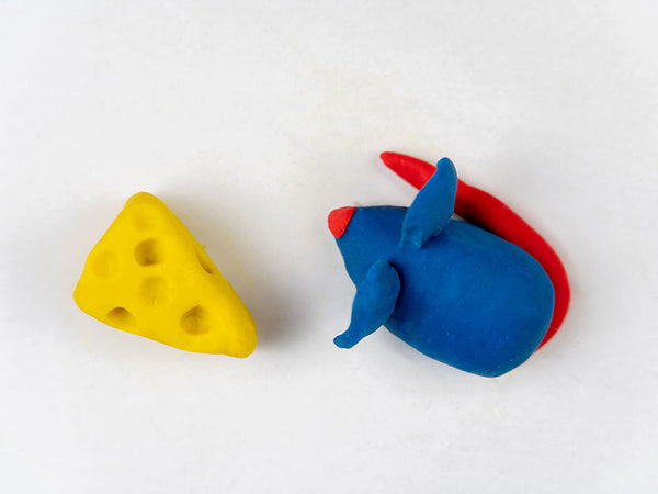 Blue dough mouse with a red nose and tail, next to the yellow cheese