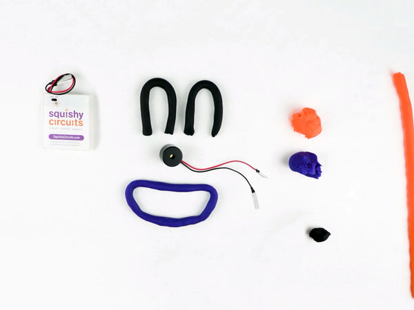 Purple dough smile and black dough arches for eyes