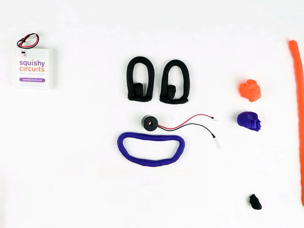 Black dough eye shapes above the purple smile