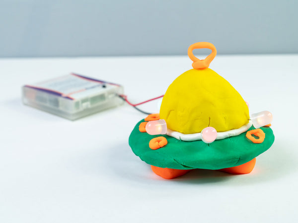 Dough UFO with a yellow dome and an orange antenna, wired to the battery holder