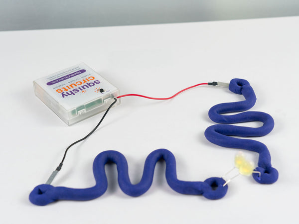 Purple dough squiggle circuit with a glowing LED, wired to the battery holder