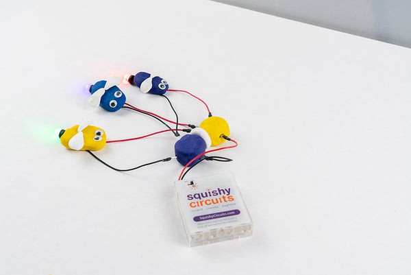 Three fireflies with glowing wired LEDs, wired to the module and battery holder