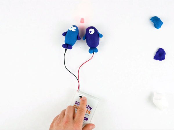 Dough buddies holding a glowing LED between their heads, wired to the battery holder
